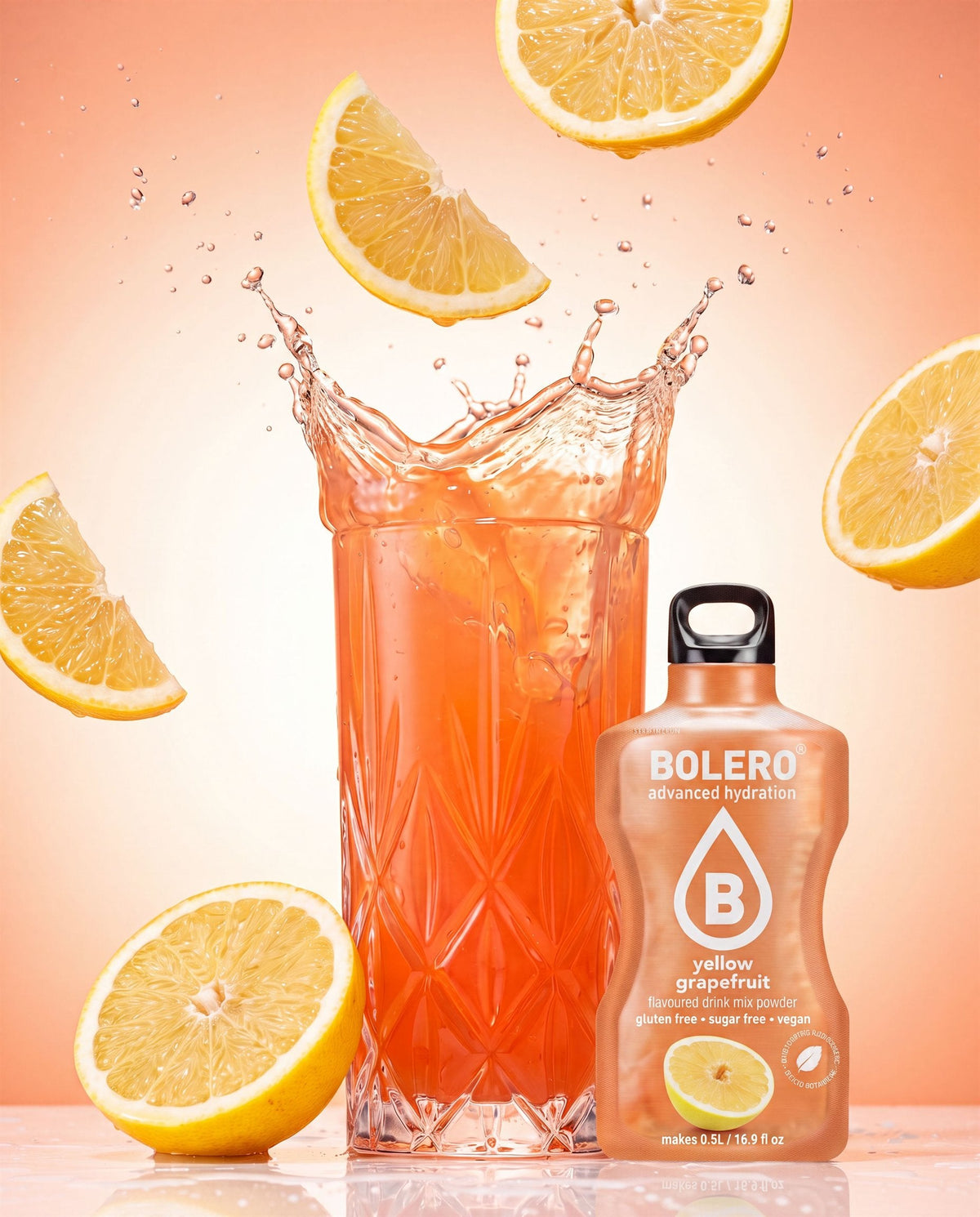 Glas mit Gelbe-Grapefruit-Drink im Splash, daneben das Bolero-Päckchen