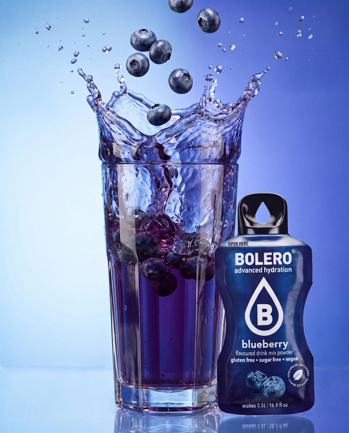 Glas mit Heidelbeer-Drink im Splash, daneben das Bolero-Päckchen