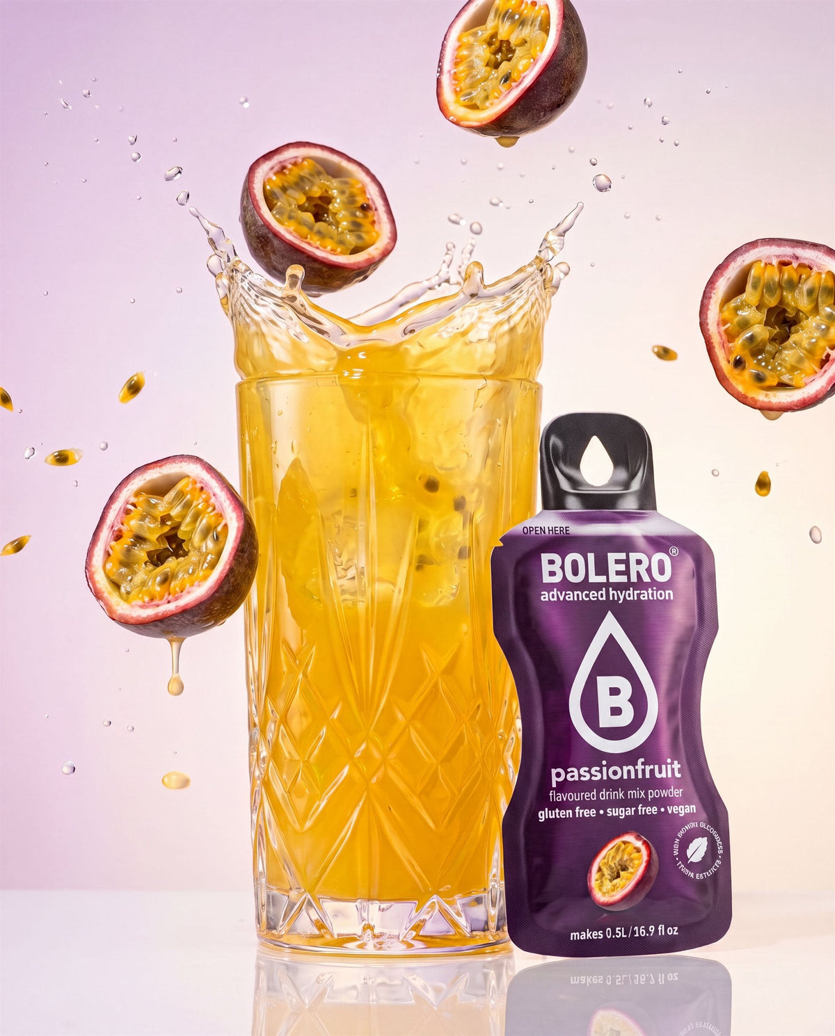 Glas mit Passionsfrucht-Drink im Splash, daneben das Bolero-Päckchen