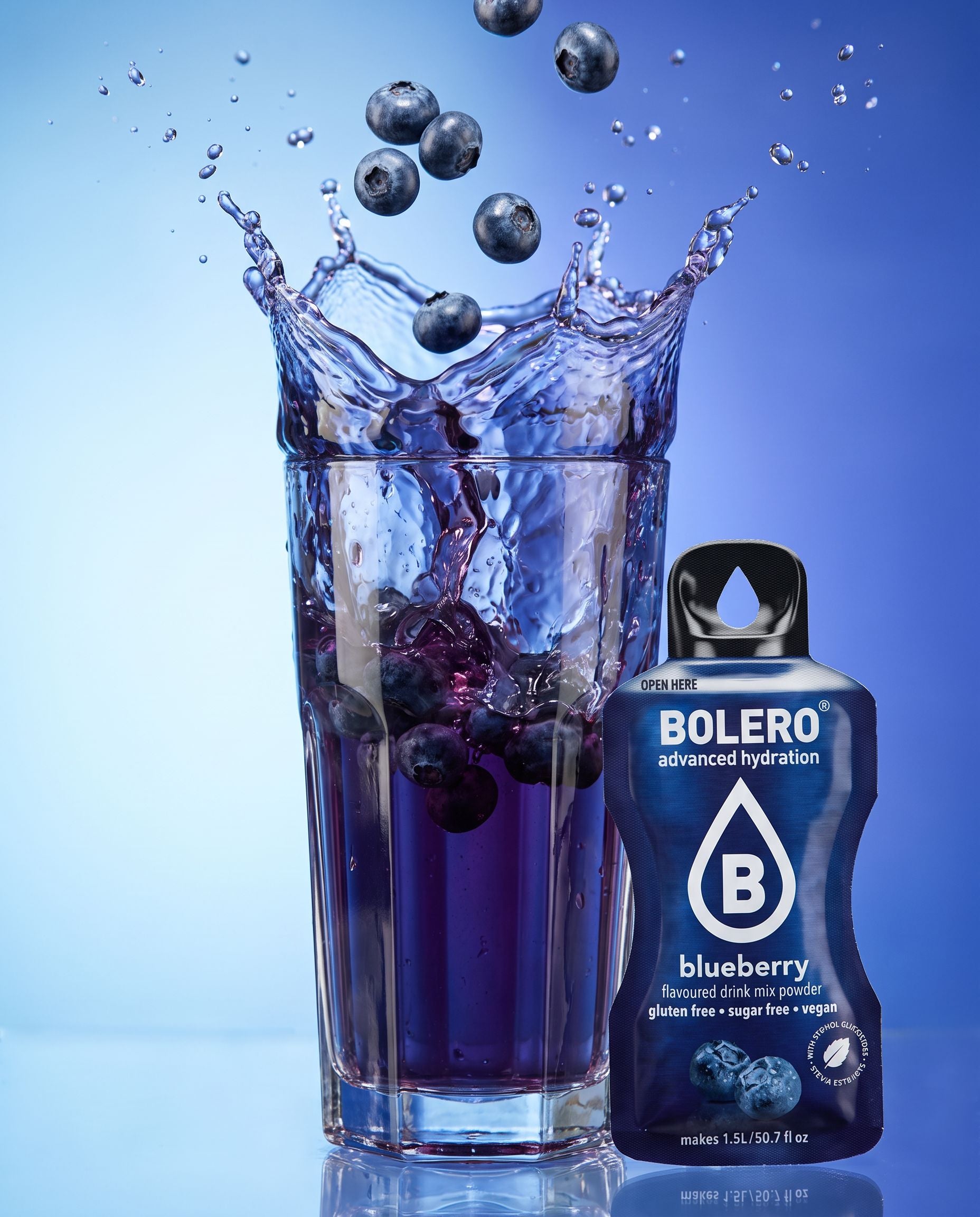 Glas mit Heidelbeere-Drink im Splash, daneben das Bolero-Päckchen